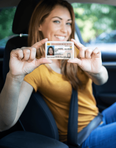 Woman holding a New Mexico driver's license and smiling